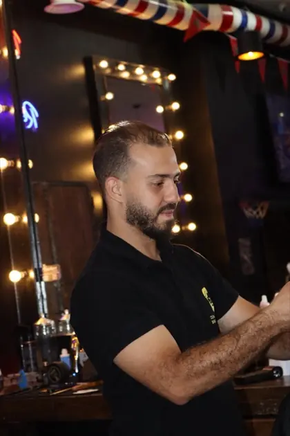 Portrait en salon de coiffure, éclairage chaud.