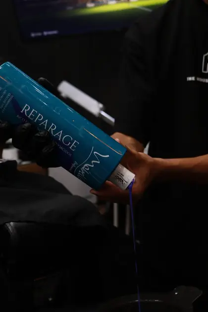 Gros plan sur un soin capillaire professionnel en barbershop.