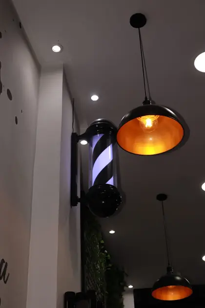 Détail d'enseigne de barbier et suspensions du salon.